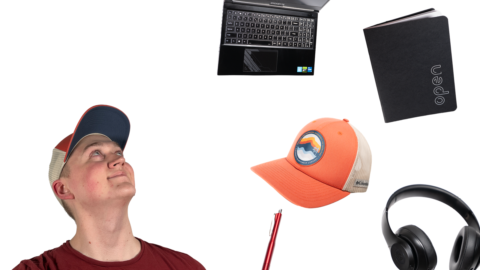 Matt Gustavel wearing a baseball cap looks upward against a black background while everyday items—an open laptop, a notebook, a baseball cap, a pen, and over-ear headphones—float around him.